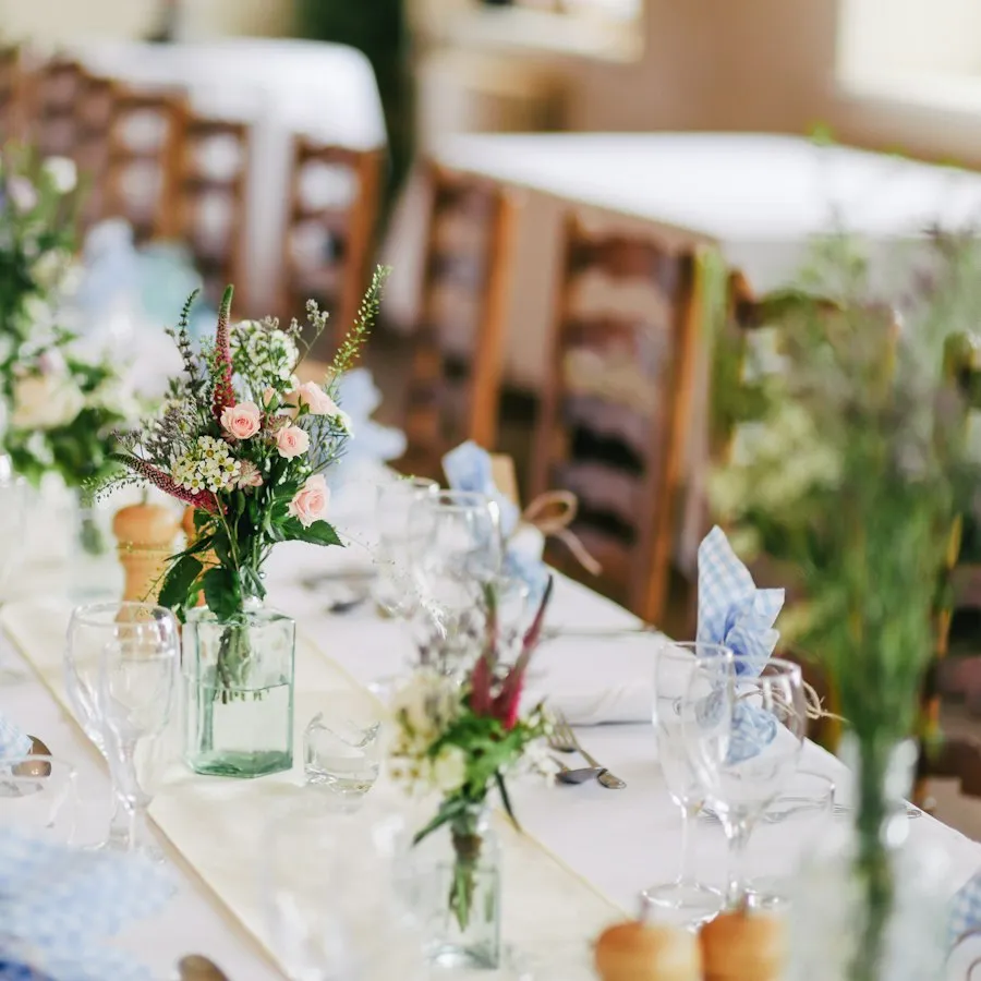 Lange Festtafel mit Wildblumen und Gläsern